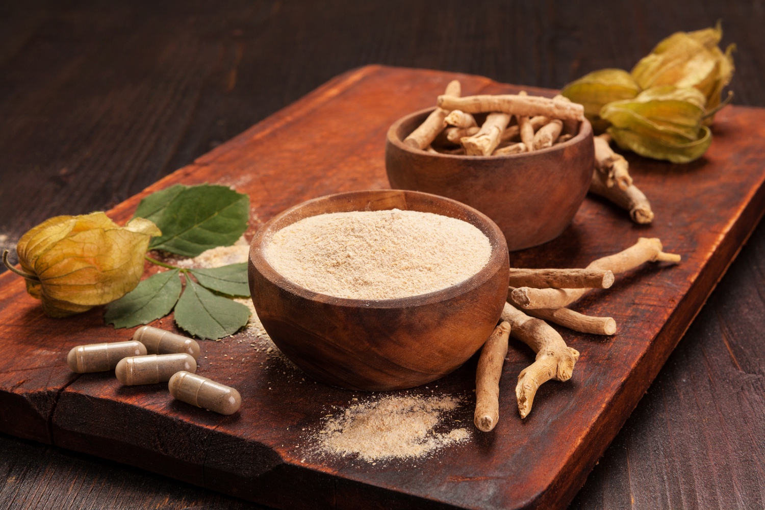 Roots and powder of Ashwagandha also known as Indian ginseng on wooden background.