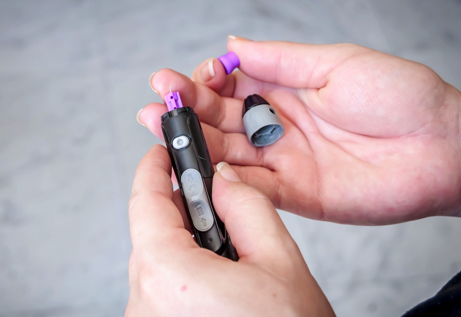 Young pregnant Caucasian woman making herself a blood sugar test to monitor the glucose level in her blood.