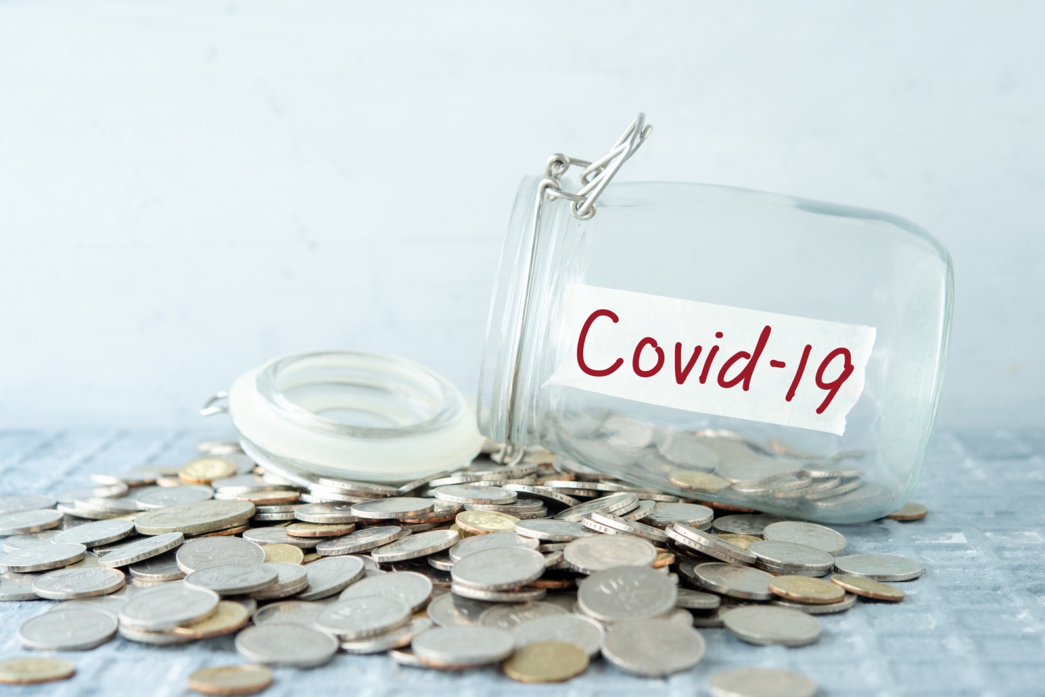 Coins in glass money jar with covid19 label, financial concept.