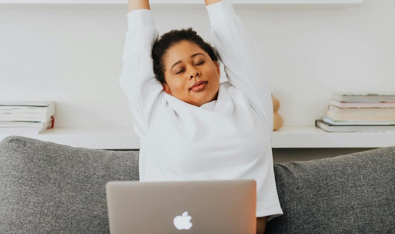 girl with laptop on lap stretching