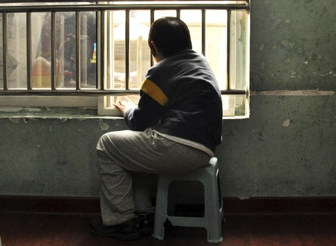 An autistic child looks out of the window at a school for autistic children in Tianjin municipality March 31, 2010.